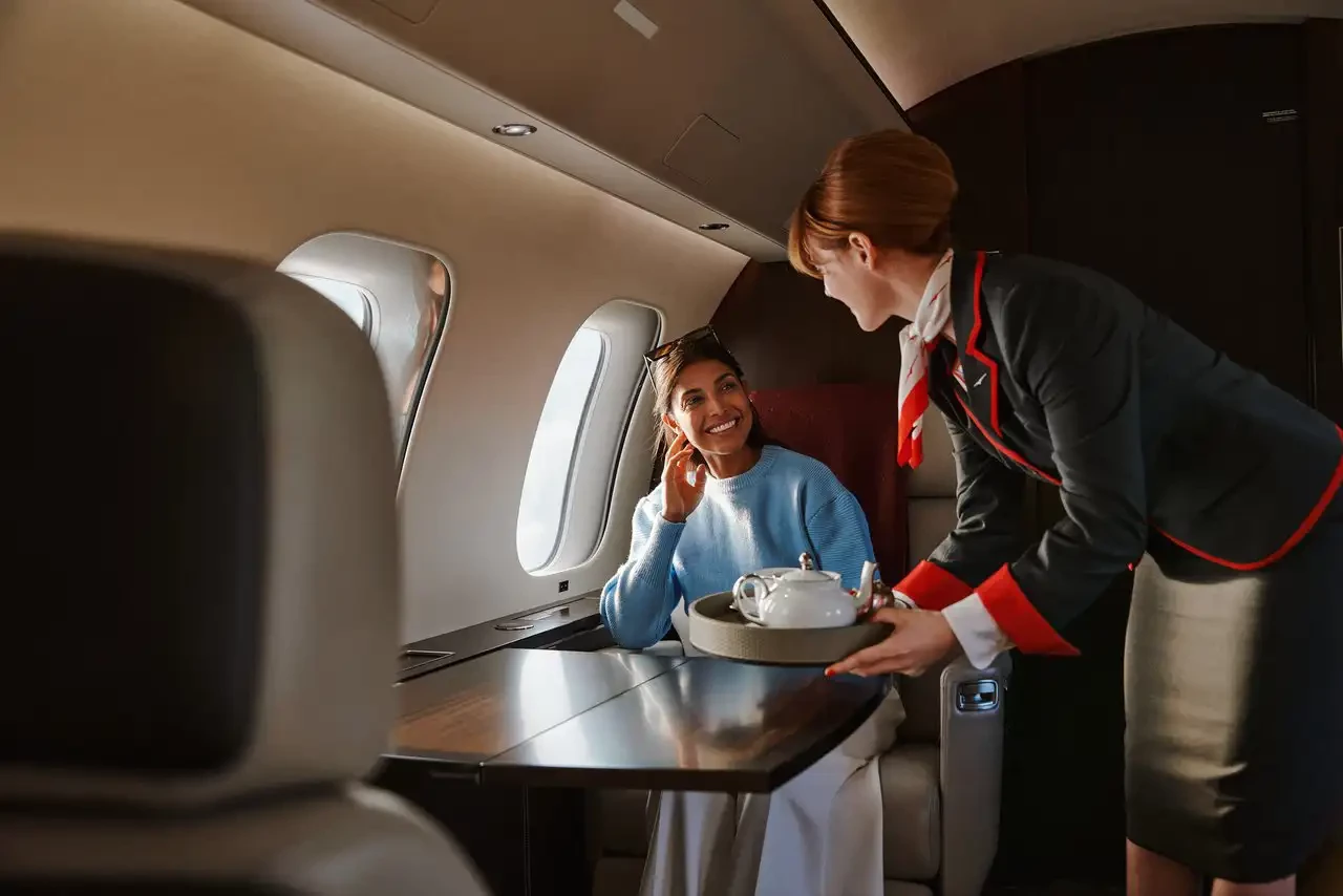 A vistaJet member in cabin, being served by VistaJet cabin crew