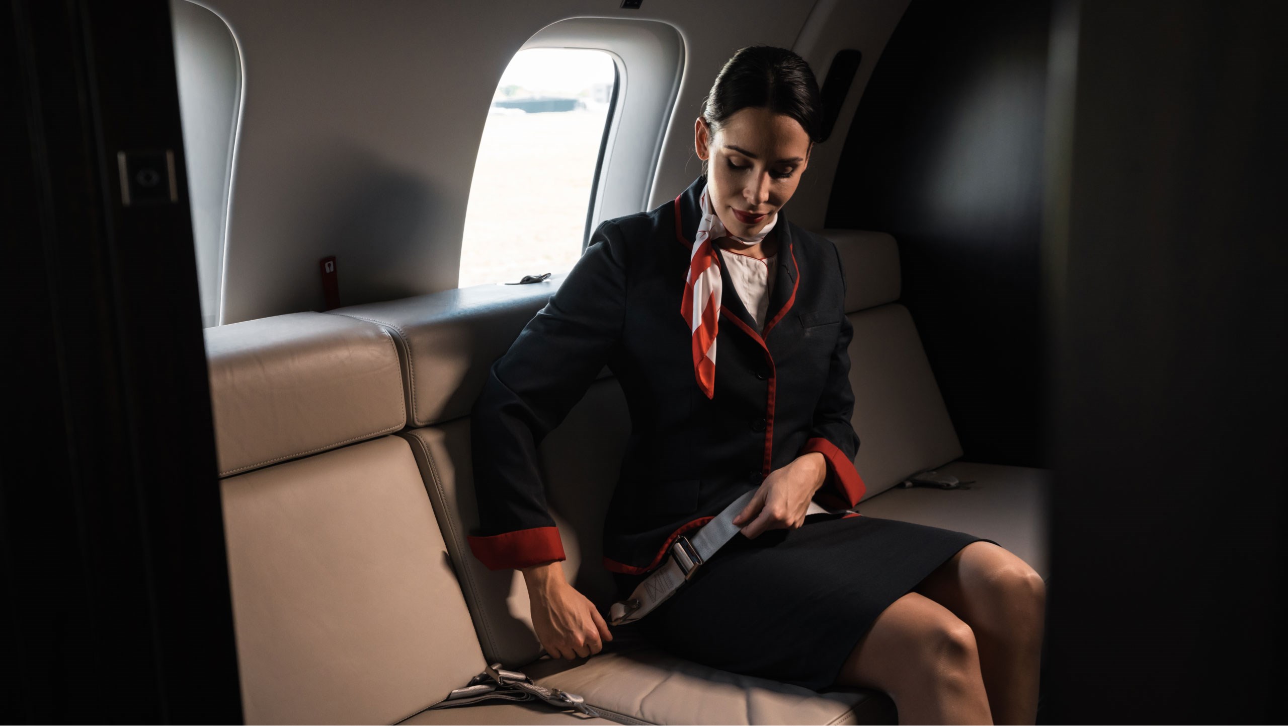 Private jet safety - Cabin host putting on seatbelt